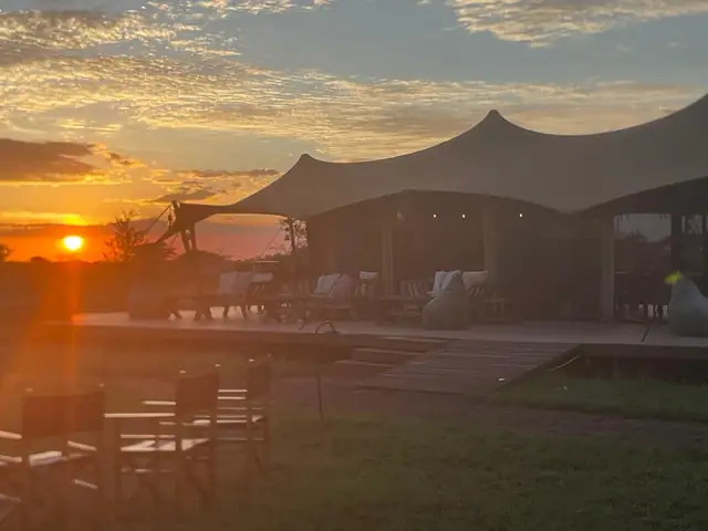 Lodge de safari con el sol poniéndose sobre la sabana