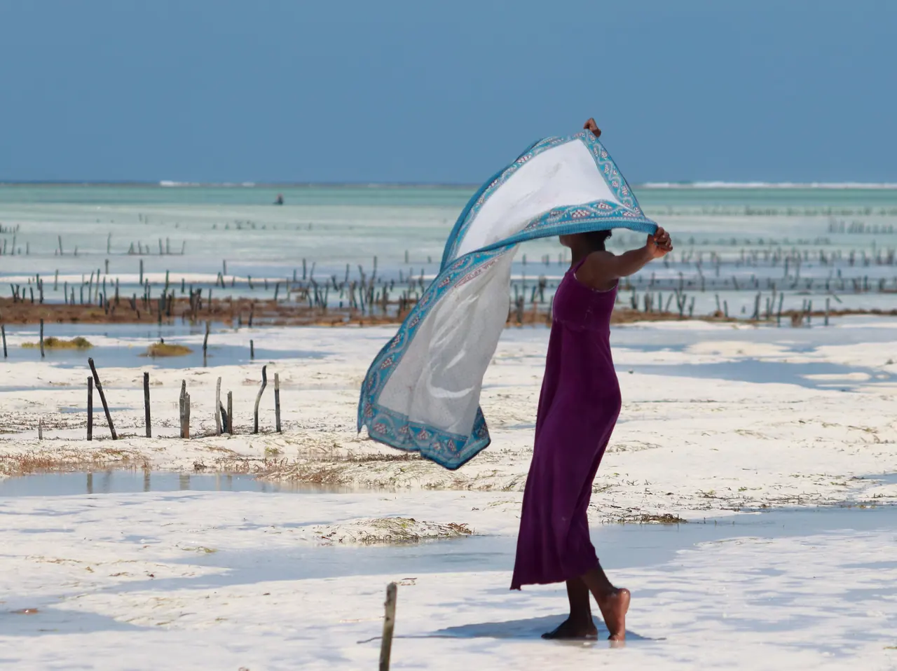 Mujer jugando con el viento en la playa de Paje, Zanzíbar